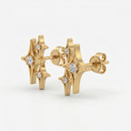 Gold starburst stud earrings at 45-degree angle showing layered celestial design and sparkling crystal details