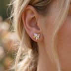 Gold flower stud earrings with sparkling marquise diamonds on white background for elegant everyday jewelry wear