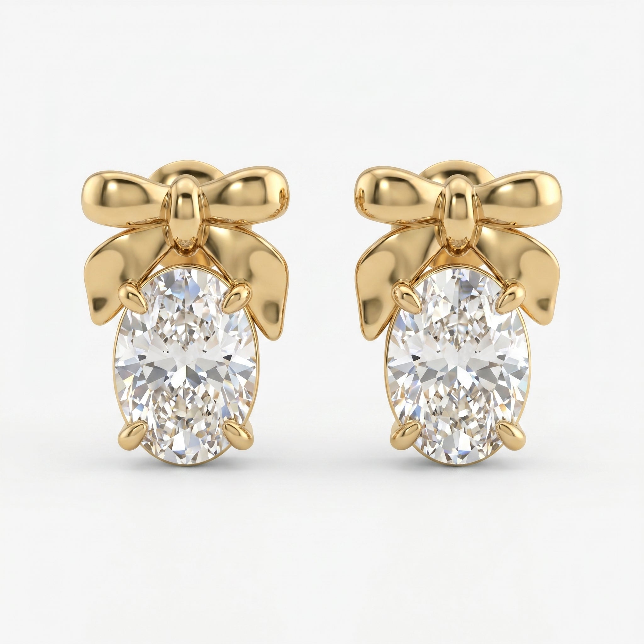 Luxury yellow gold bow stud earrings with oval-cut diamond stones on a clean white background