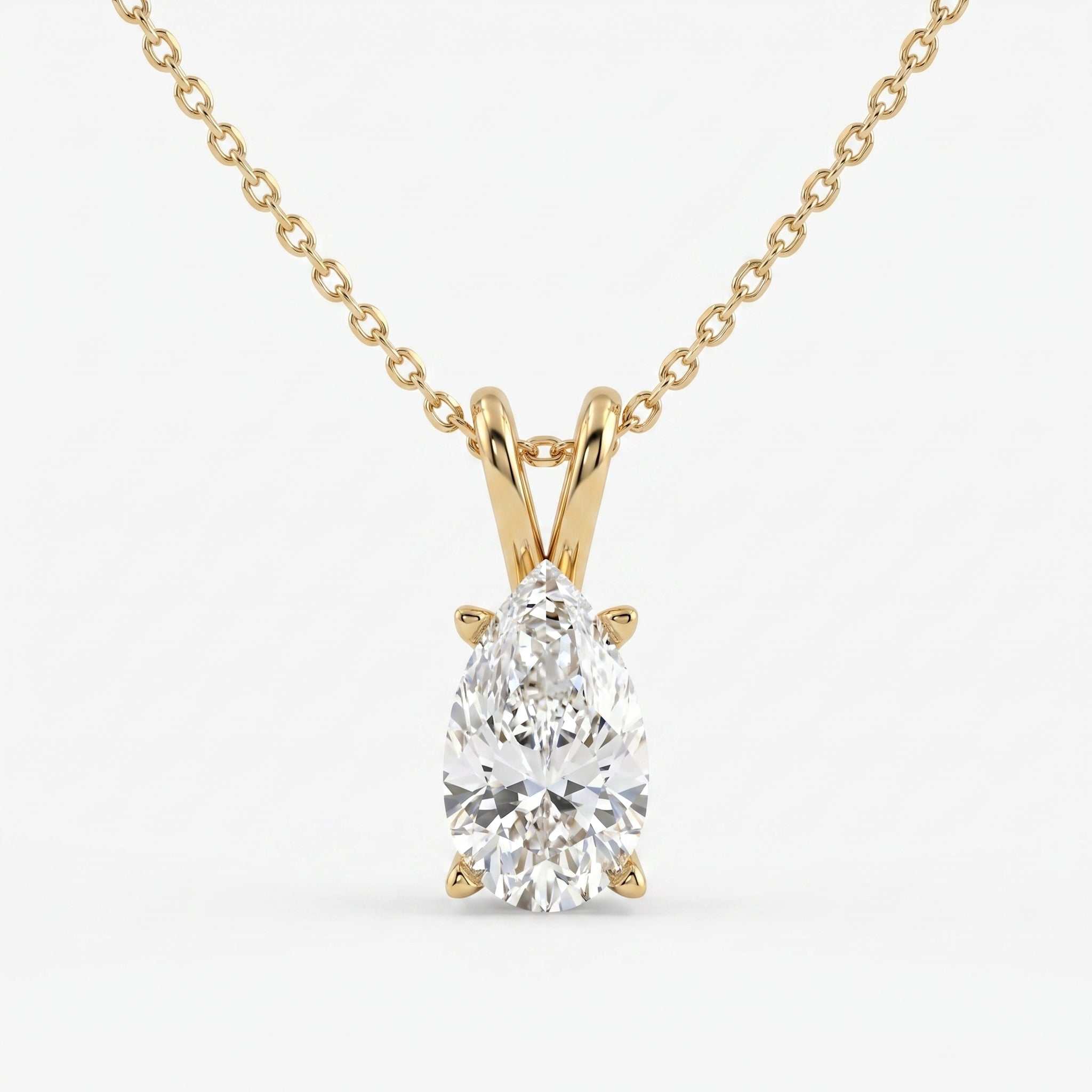 Gold necklace with a pear-shaped diamond pendant on a white background