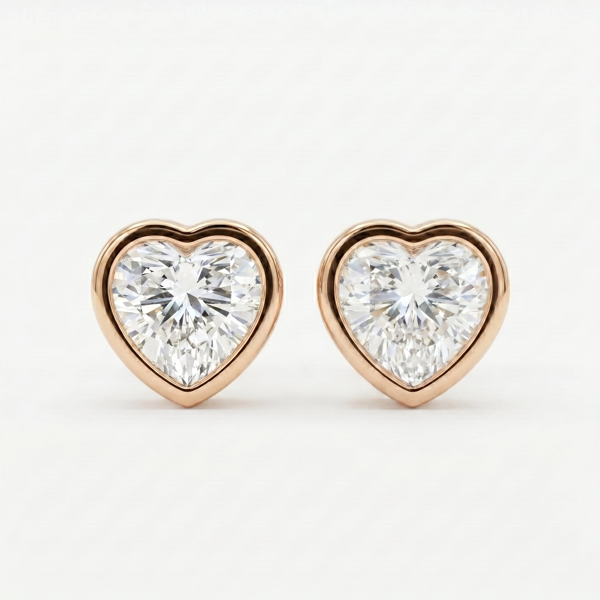 Heart-shaped diamond earrings with rose gold setting on a white background