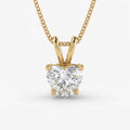 Gold necklace with a heart-shaped diamond pendant on a white background