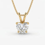 Gold necklace with a heart-shaped diamond pendant on a white background