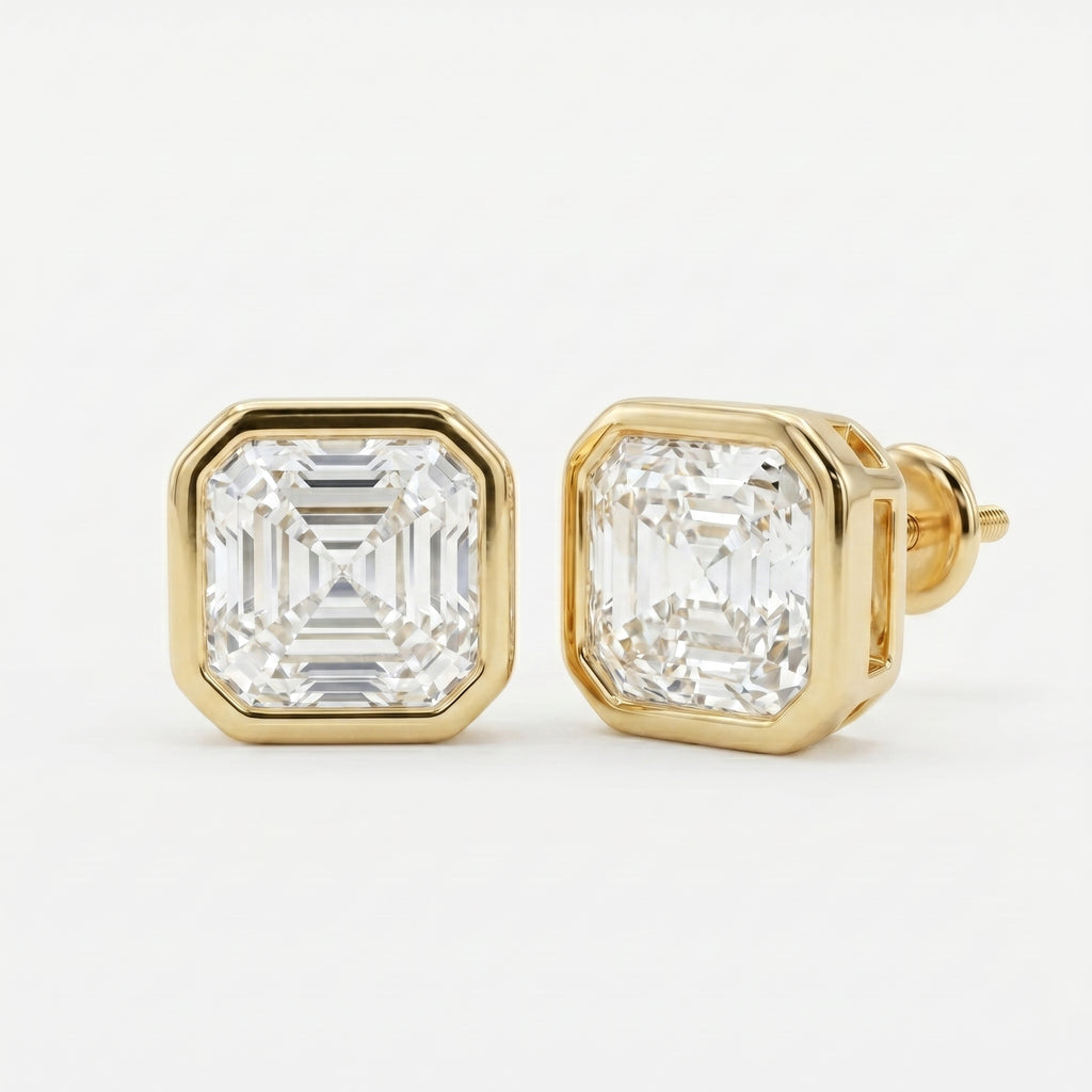 Gold earrings with emerald-cut diamonds on a white background