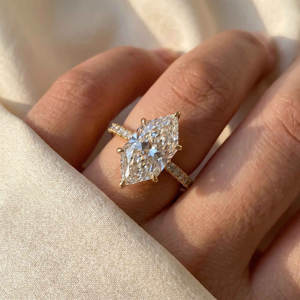 Marquise diamond engagement ring worn on hand featuring elegant pavé band and timeless luxury bridal style.