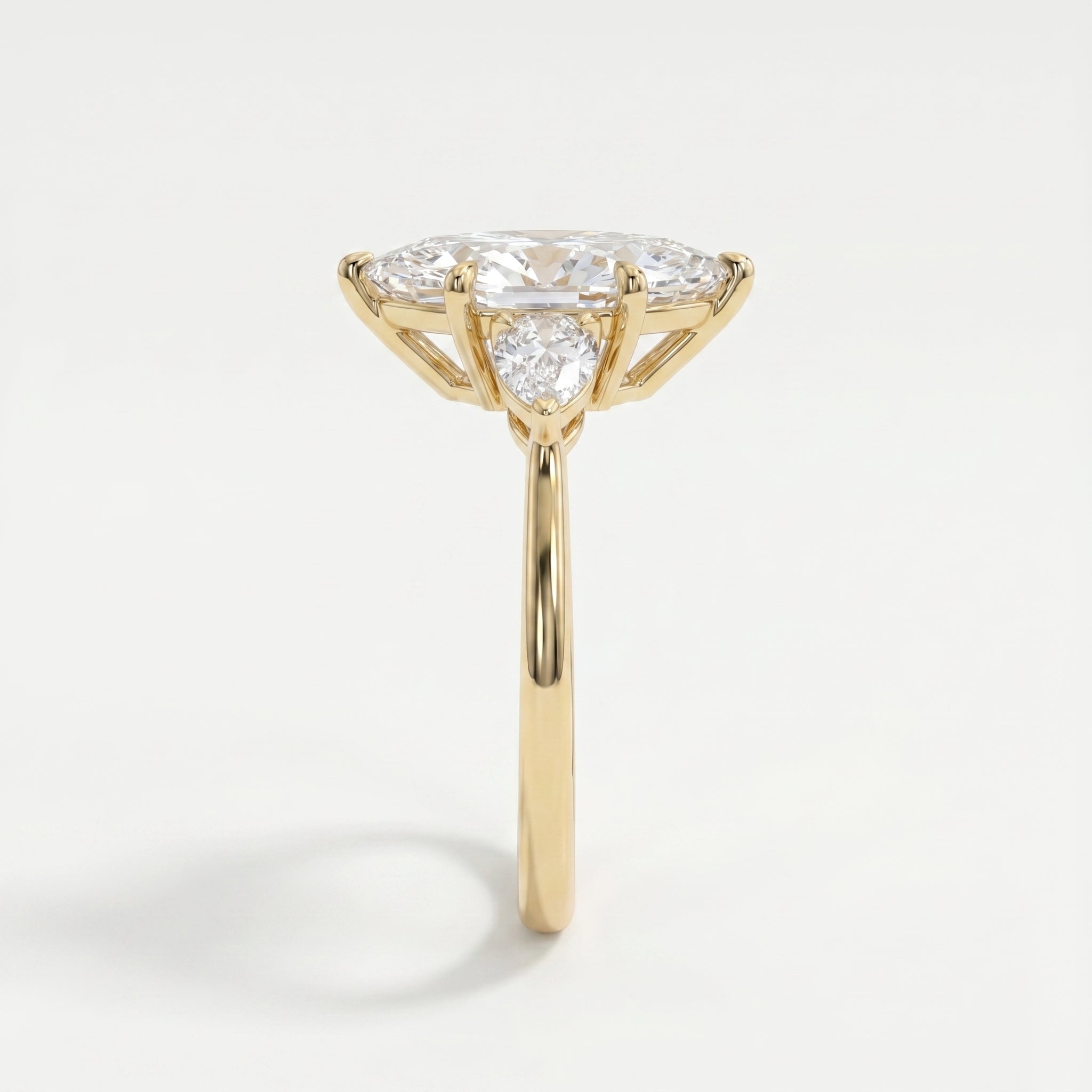 Side profile of marquise diamond engagement ring showing cathedral setting and pear accent diamonds