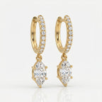 Luxury yellow gold hoop earrings with dangling marquise diamonds photographed at elegant 45-degree angle