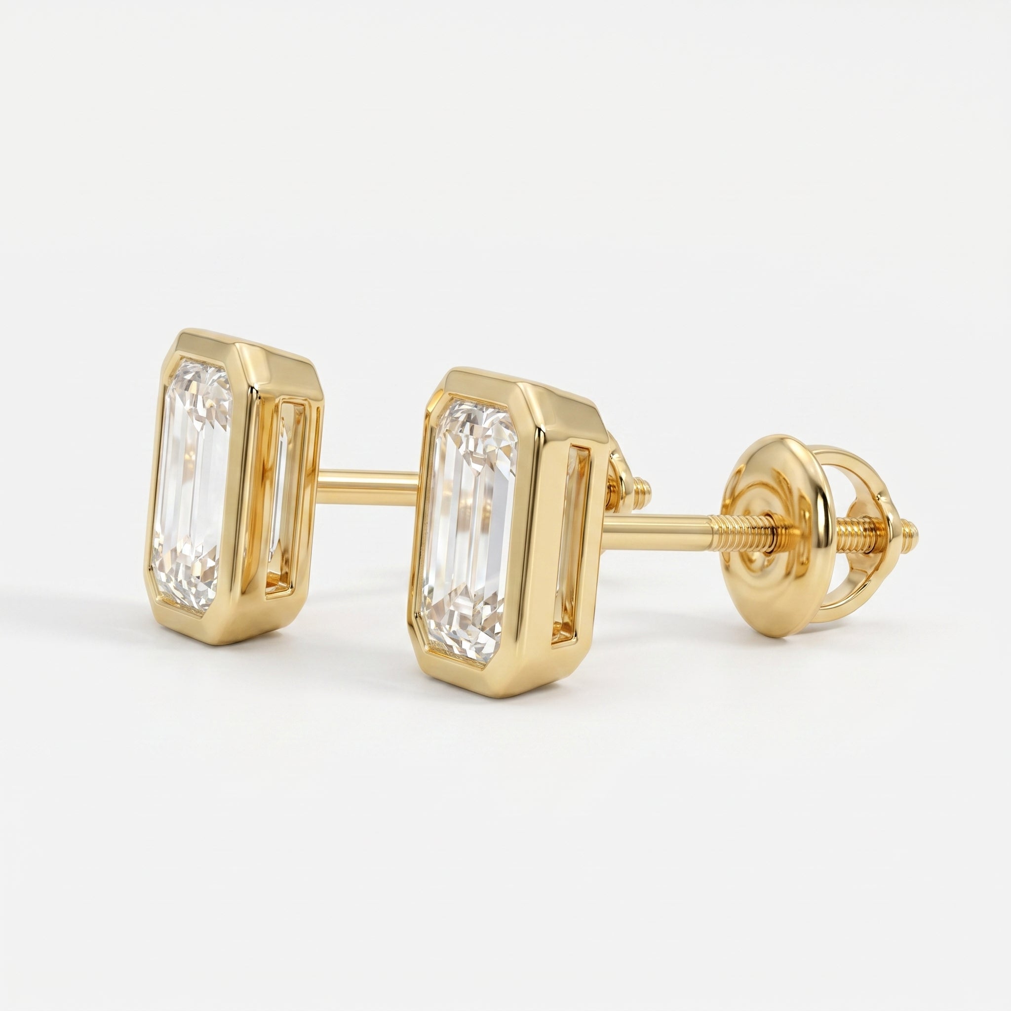 Gold earrings with emerald-cut diamonds on a white background