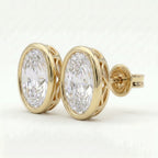 Yellow gold oval stud earrings with bezel setting shown at luxury 45-degree angle with high brilliance