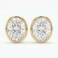 Pair of diamond stud earrings with gold rims on a white background