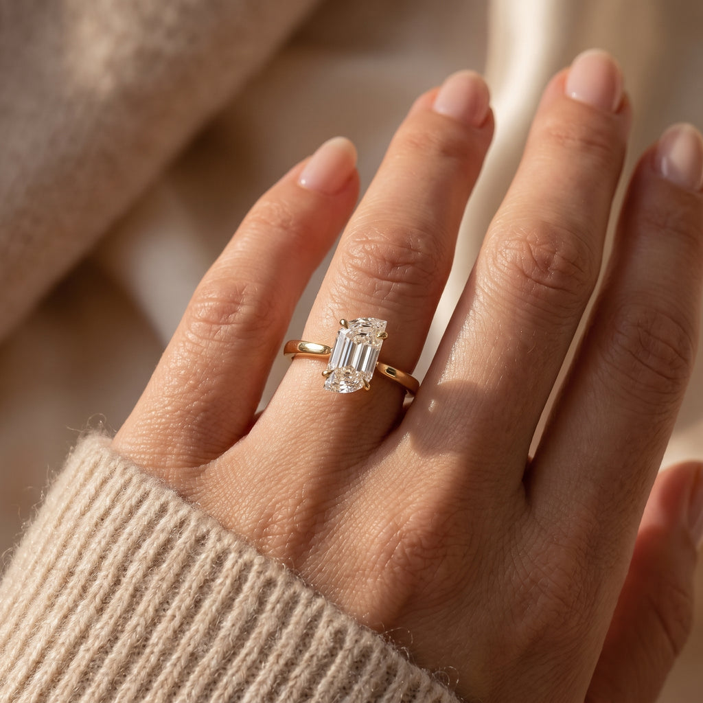 Flame cut diamond solitaire engagement ring in polished yellow gold worn on hand with elegant minimalist design.