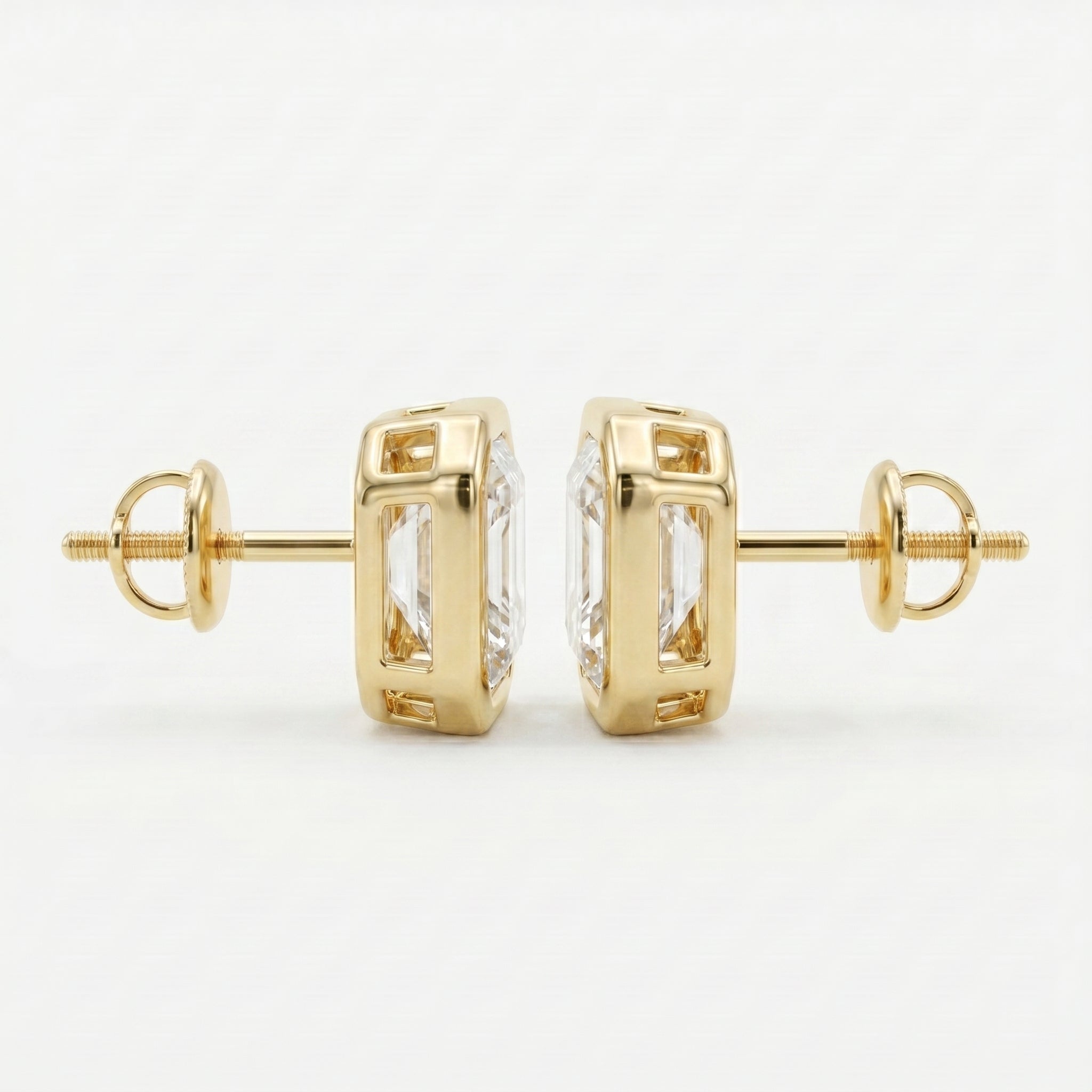 Gold earrings with clear gemstones on a white background