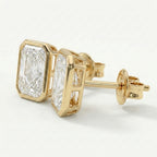 Gold earrings with diamond-like stones on a white background