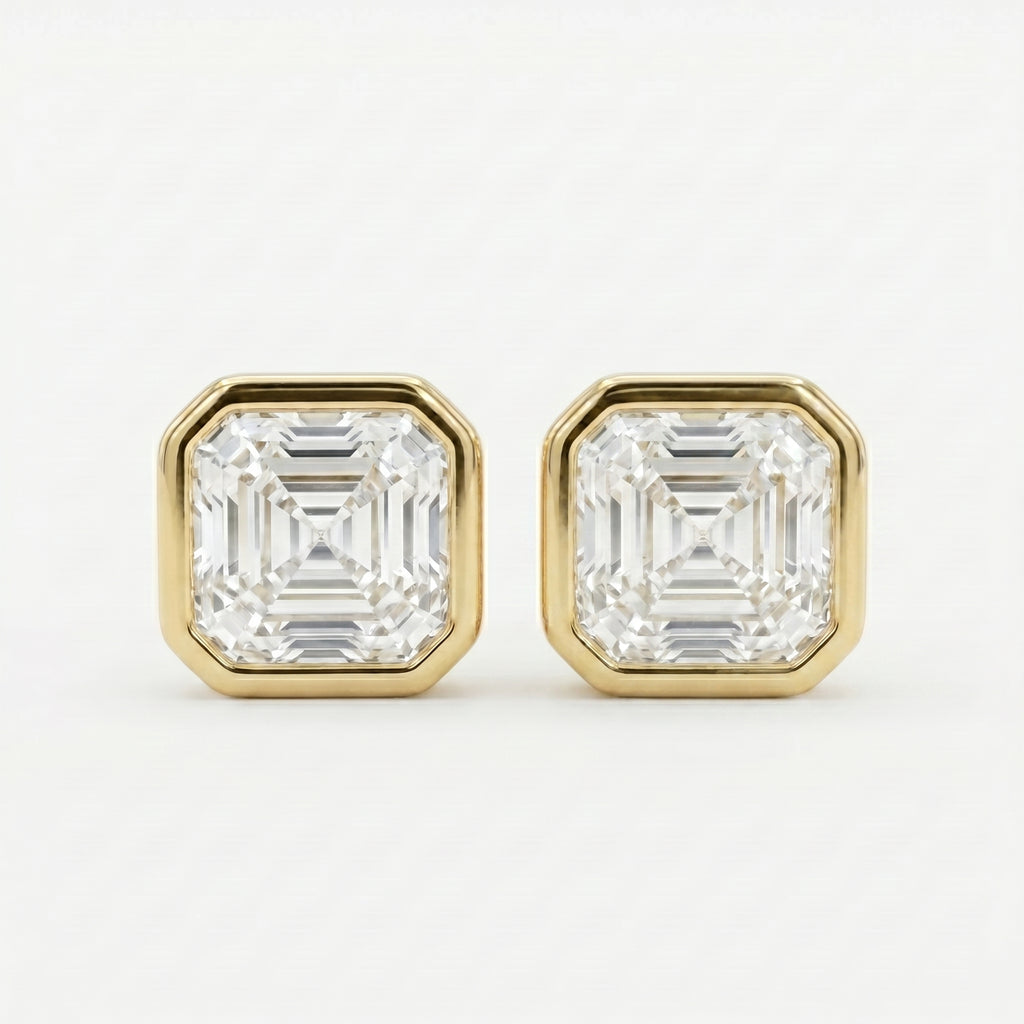 Gold earrings with Ascher-cut gemstones on a white background