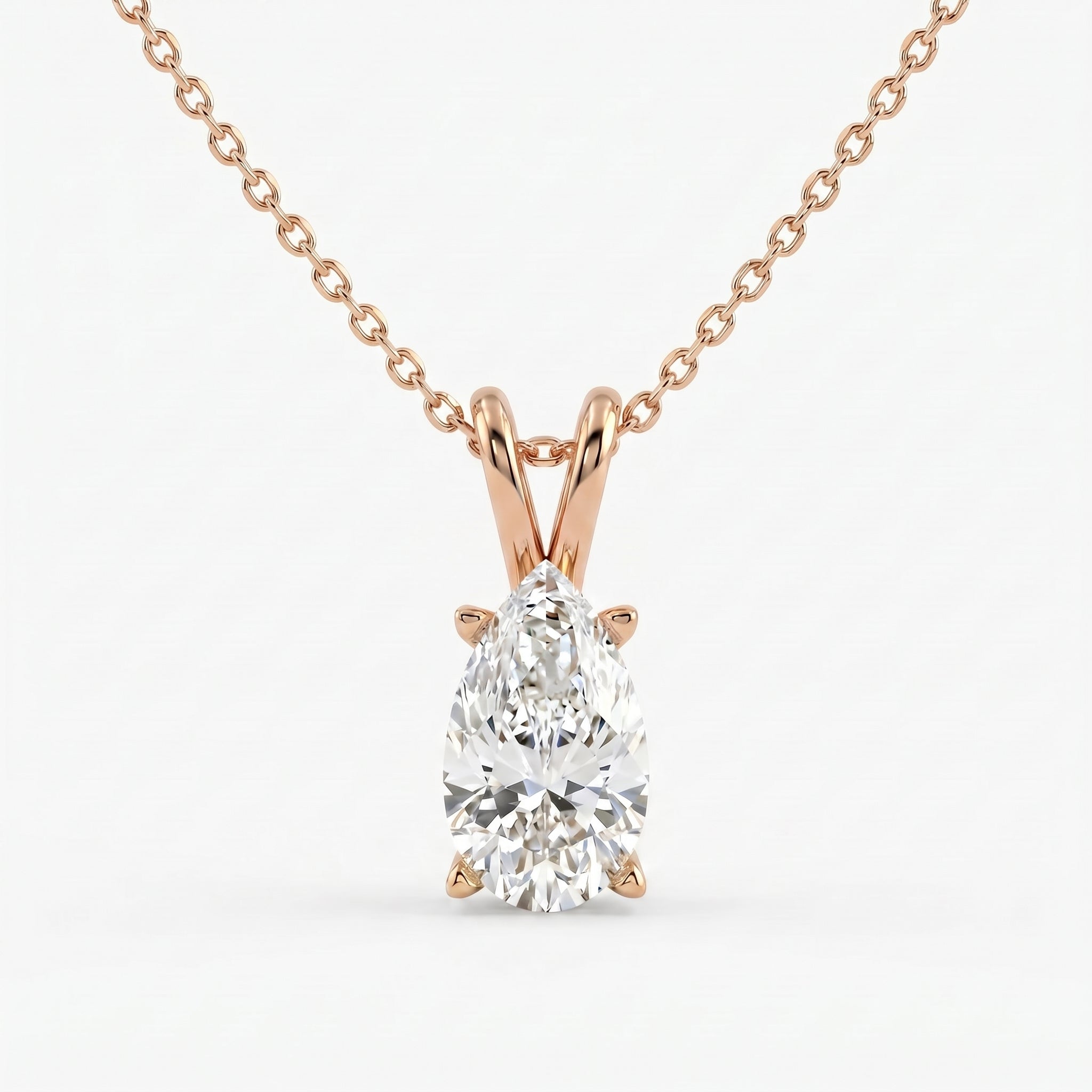 Rose gold necklace with a pear-shaped diamond pendant on a white background