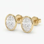 Round diamond bezel stud earrings in polished yellow gold with brilliant sparkle on white background