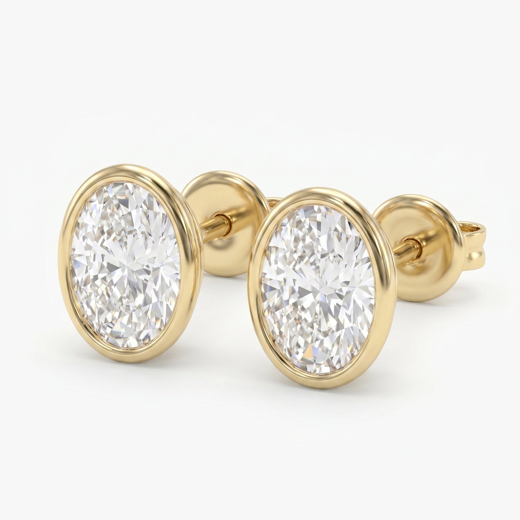 Round diamond bezel stud earrings in polished yellow gold with brilliant sparkle on white background