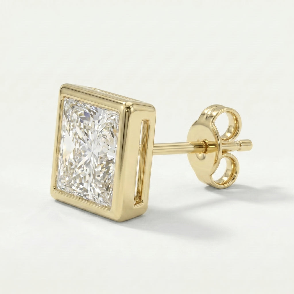 Gold earring with a clear gemstone on a light gray background
