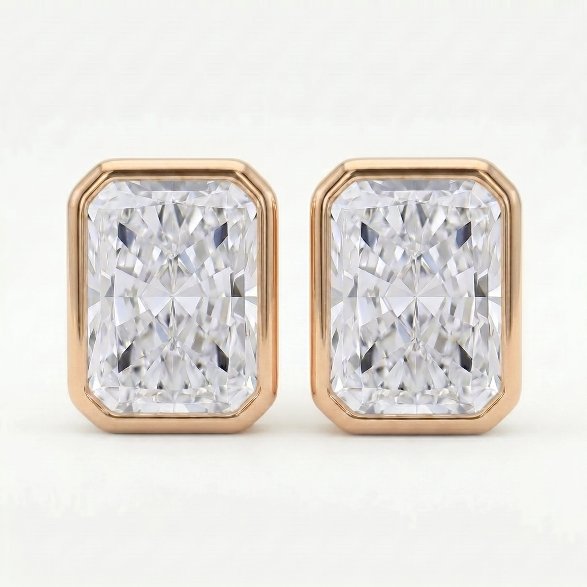 Pair of diamond stud earrings with rose gold frames on a white background