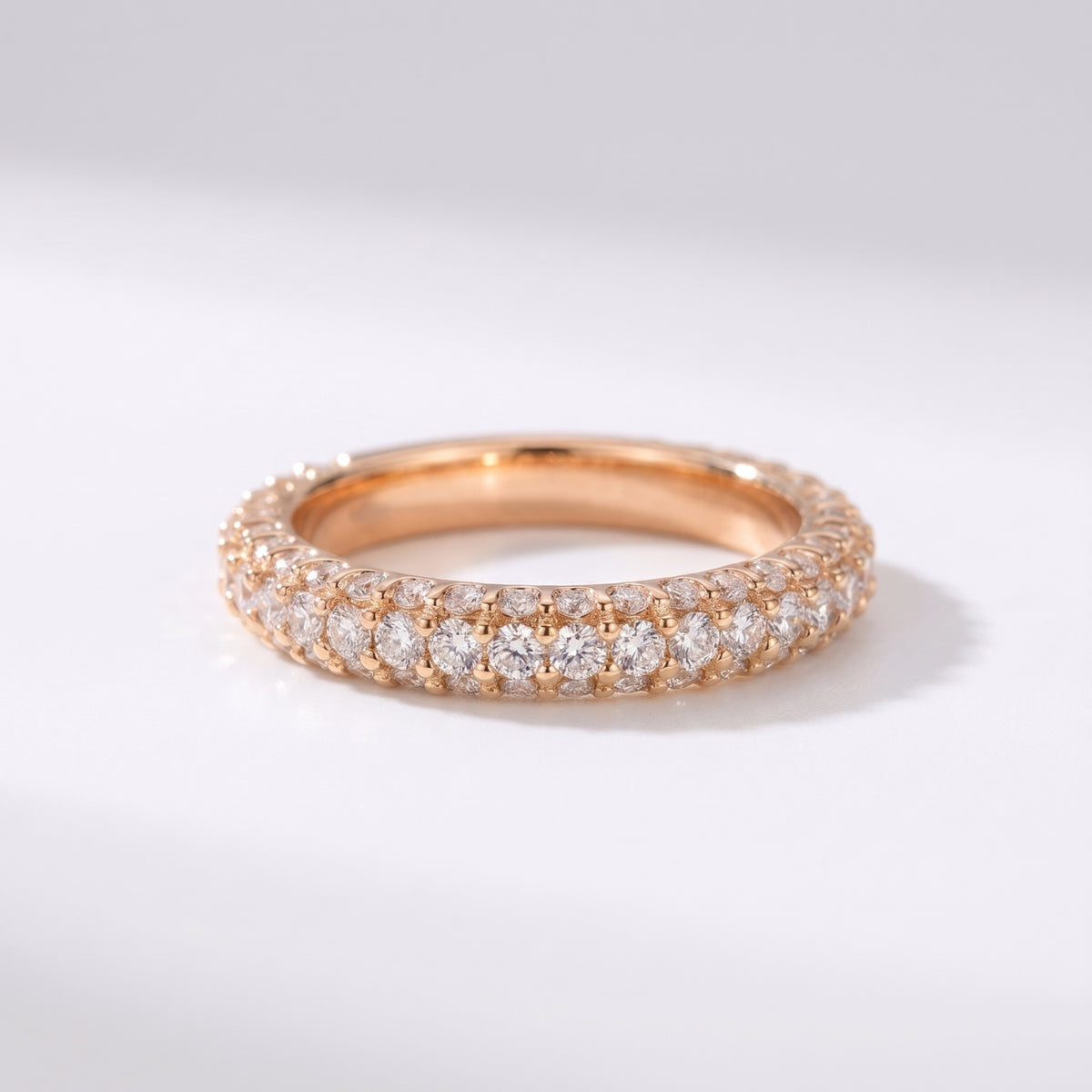 Luxury Rose Gold gold diamond eternity band with triple-row pavé setting on a pure white background.