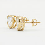 Gold earrings with clear gemstones on a light gray background