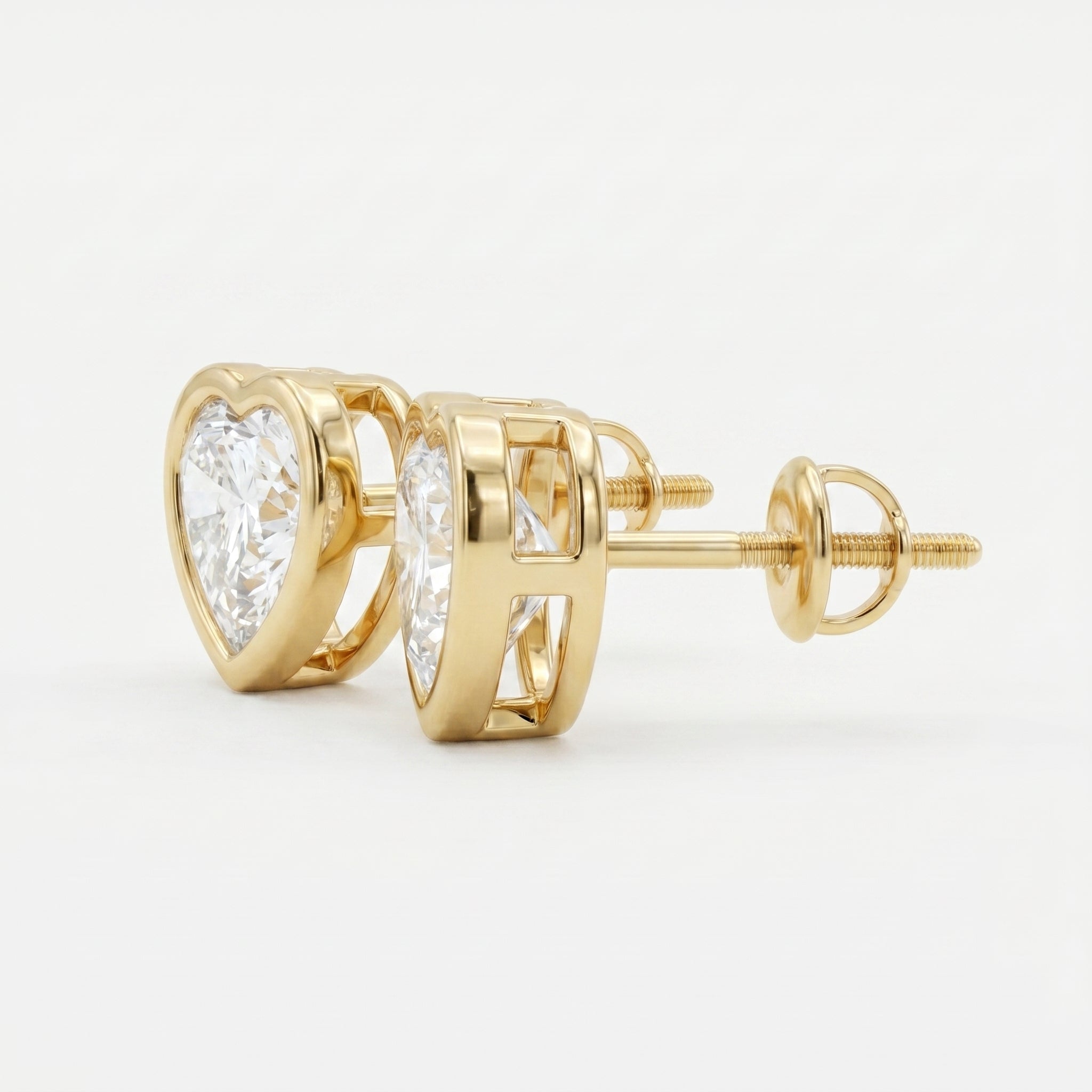 Gold earrings with clear gemstones on a light gray background