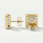Gold earrings with clear gemstones on a light background