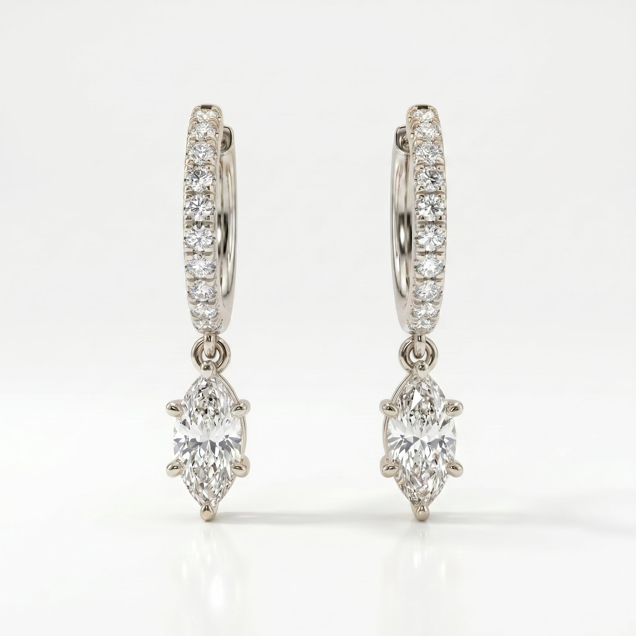 Angled view of White gold diamond drop hoop earrings with marquise-cut dangling center stones