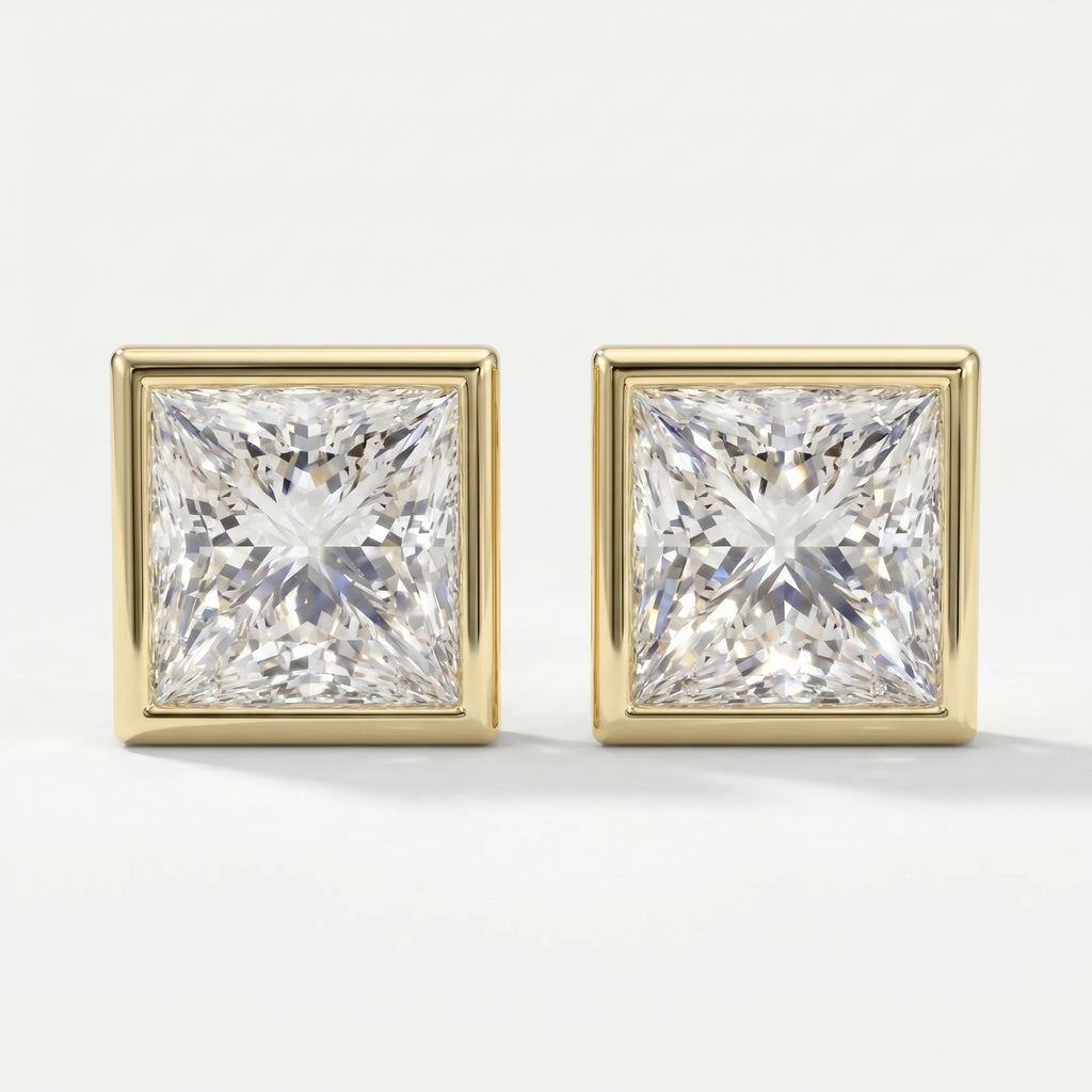 Pair of square-cut diamond earrings with gold prongs on a light gray background