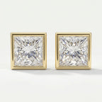 Pair of square-cut diamond earrings with gold prongs on a light gray background