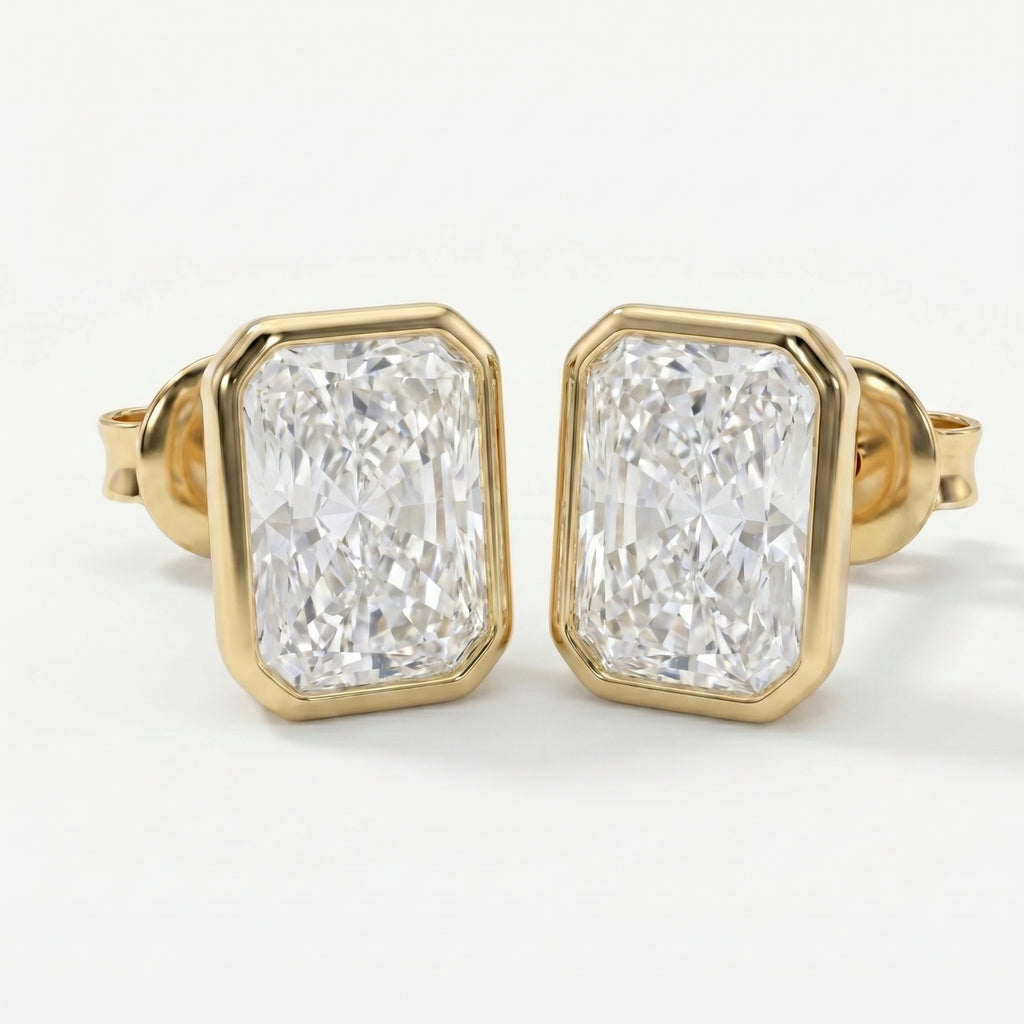 Gold earrings with large clear gemstones on a white background