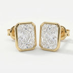Gold earrings with large clear gemstones on a white background