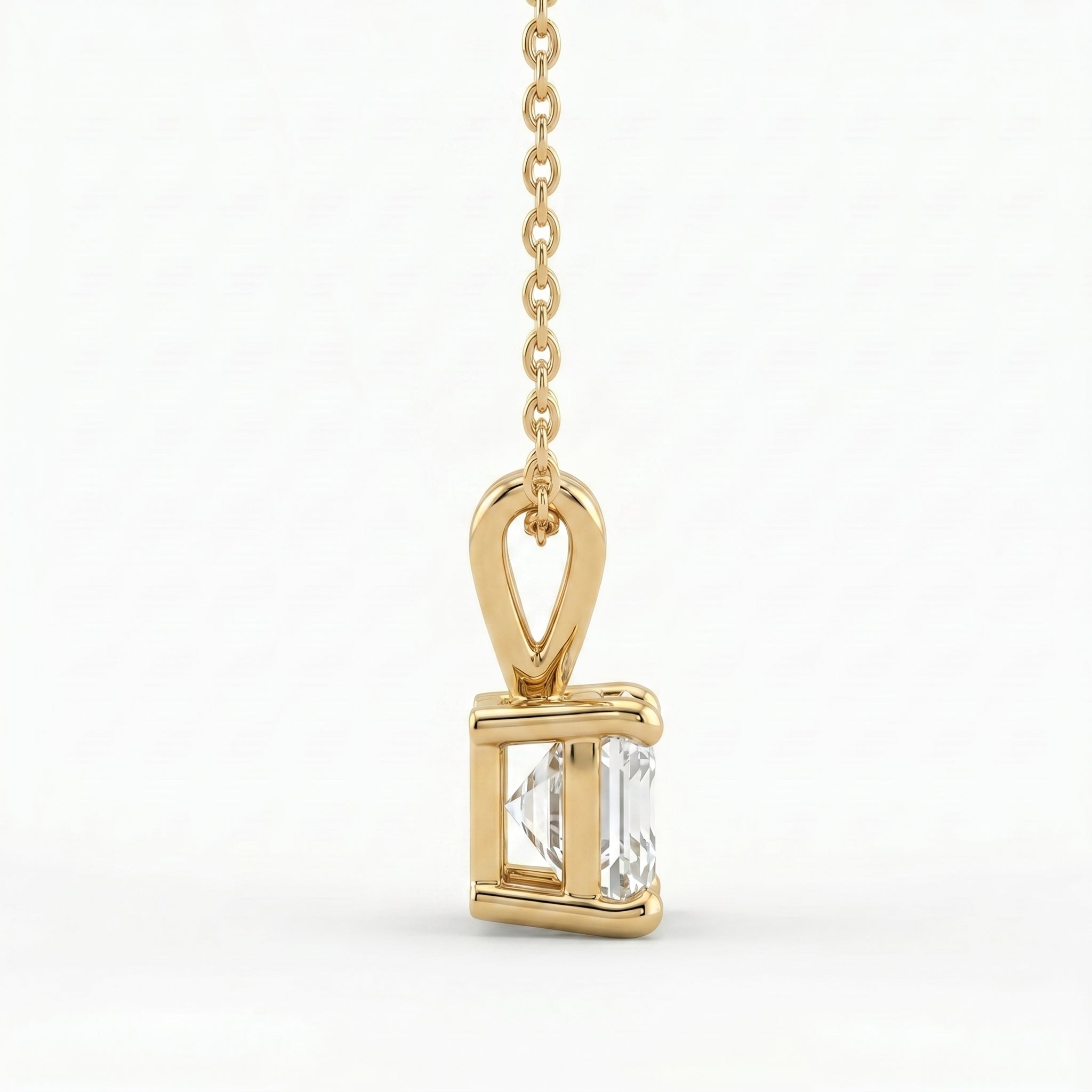 Gold pendant with a clear gemstone on a white background