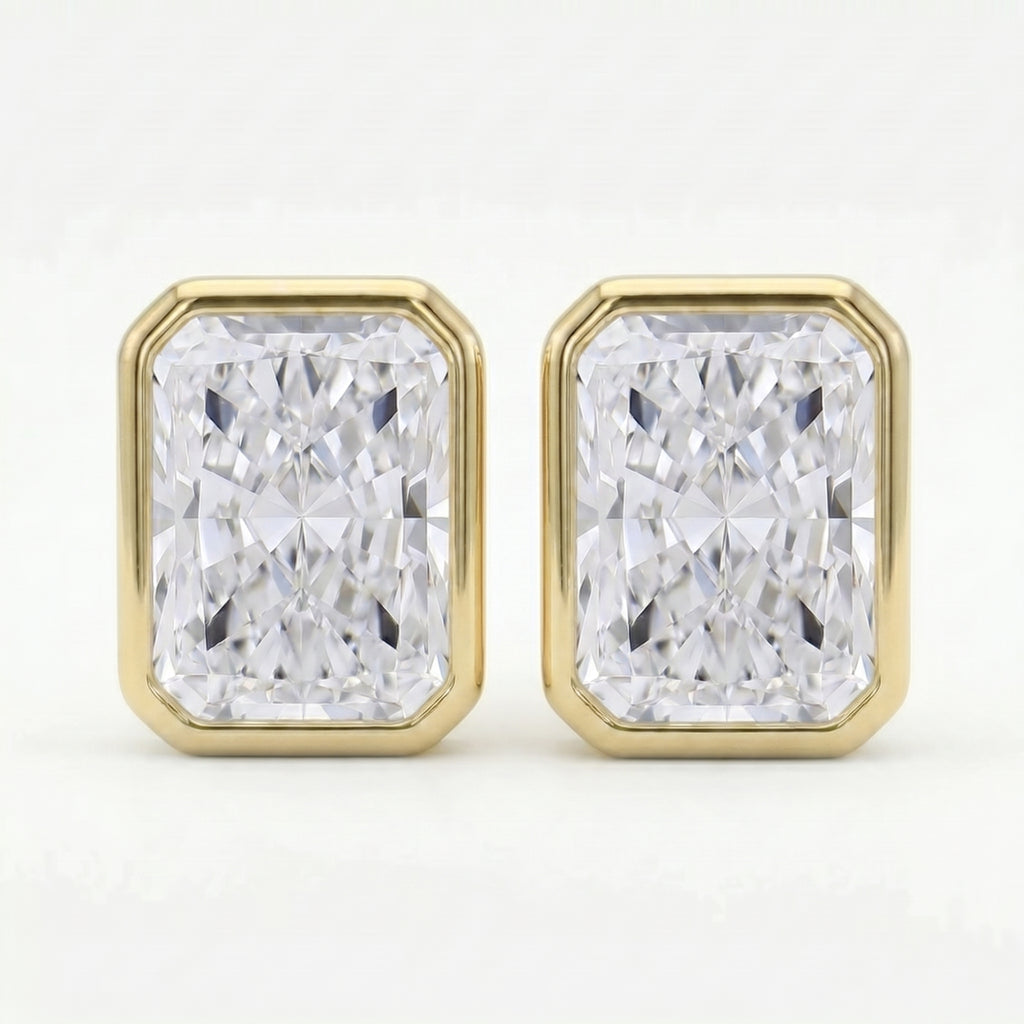 Gold earrings with rectangular diamond-like stones on a white background