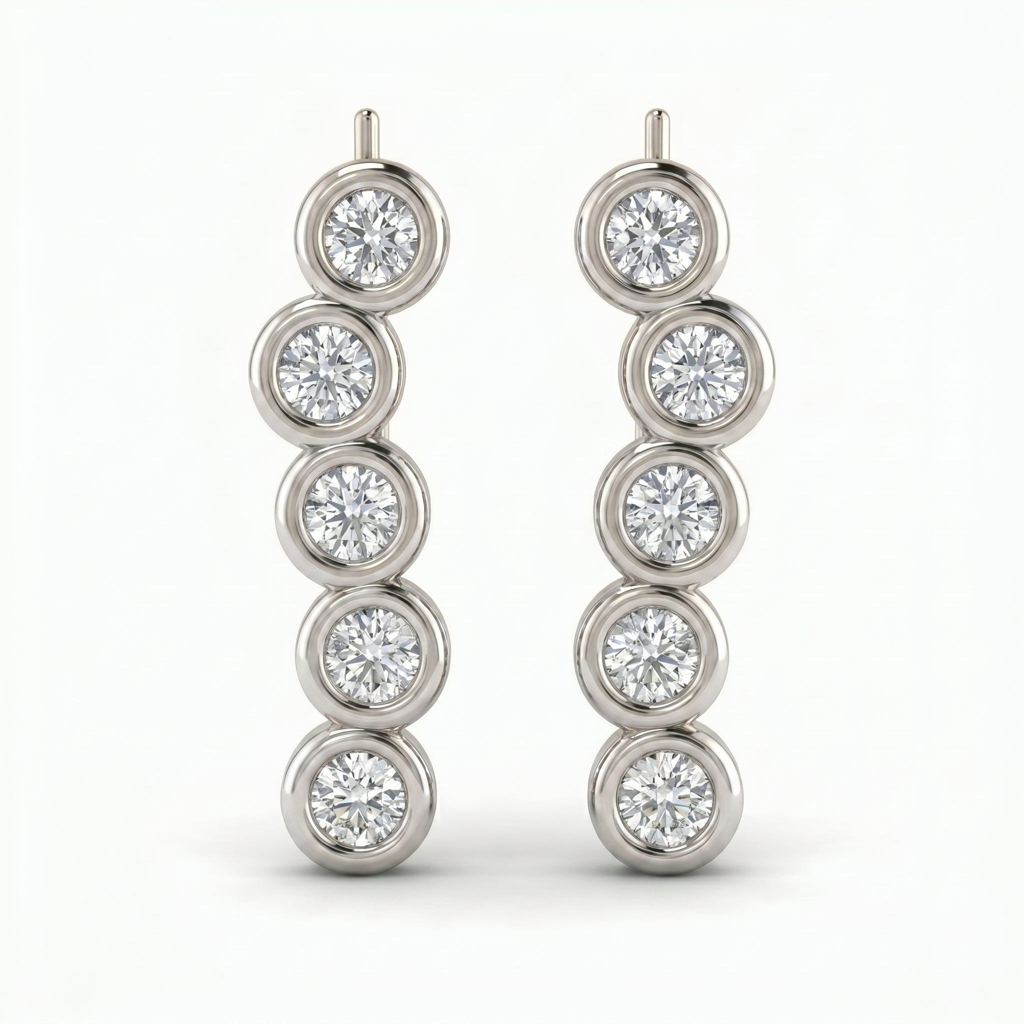 Angled view of White gold diamond climber earrings featuring bezel-set round brilliant diamonds