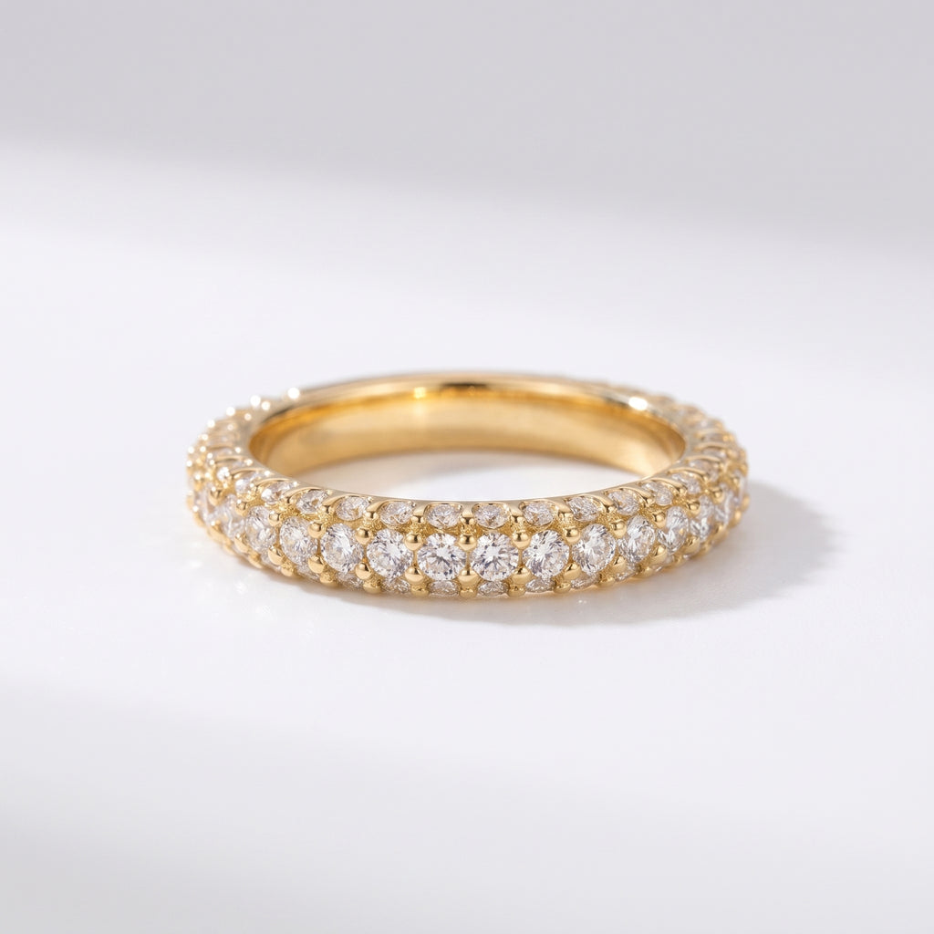 Yellow gold diamond eternity band with three rows of round brilliant pavé diamonds on a pure white background, luxury wedding ring.