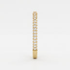 Side profile of a yellow gold eternity ring highlighting round brilliant diamonds and elegant shared prong craftsmanship.