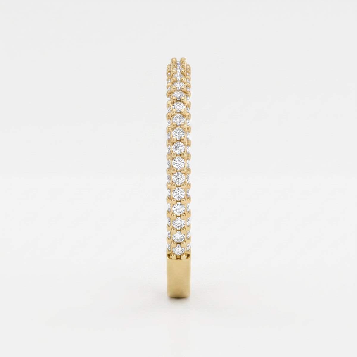 Side profile of a yellow gold eternity ring highlighting round brilliant diamonds and elegant shared prong craftsmanship.