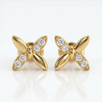 Flat lay butterfly diamond earrings styled with elegant luxury accessories on a clean white background