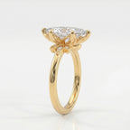45 degree view of marquise diamond engagement ring featuring yellow gold floral setting and brilliant accent stones
