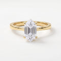 Modern elongated hexagon diamond solitaire engagement ring in polished yellow gold with a minimalist four-prong setting.