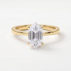 Modern elongated hexagon diamond solitaire engagement ring in polished yellow gold with a minimalist four-prong setting.