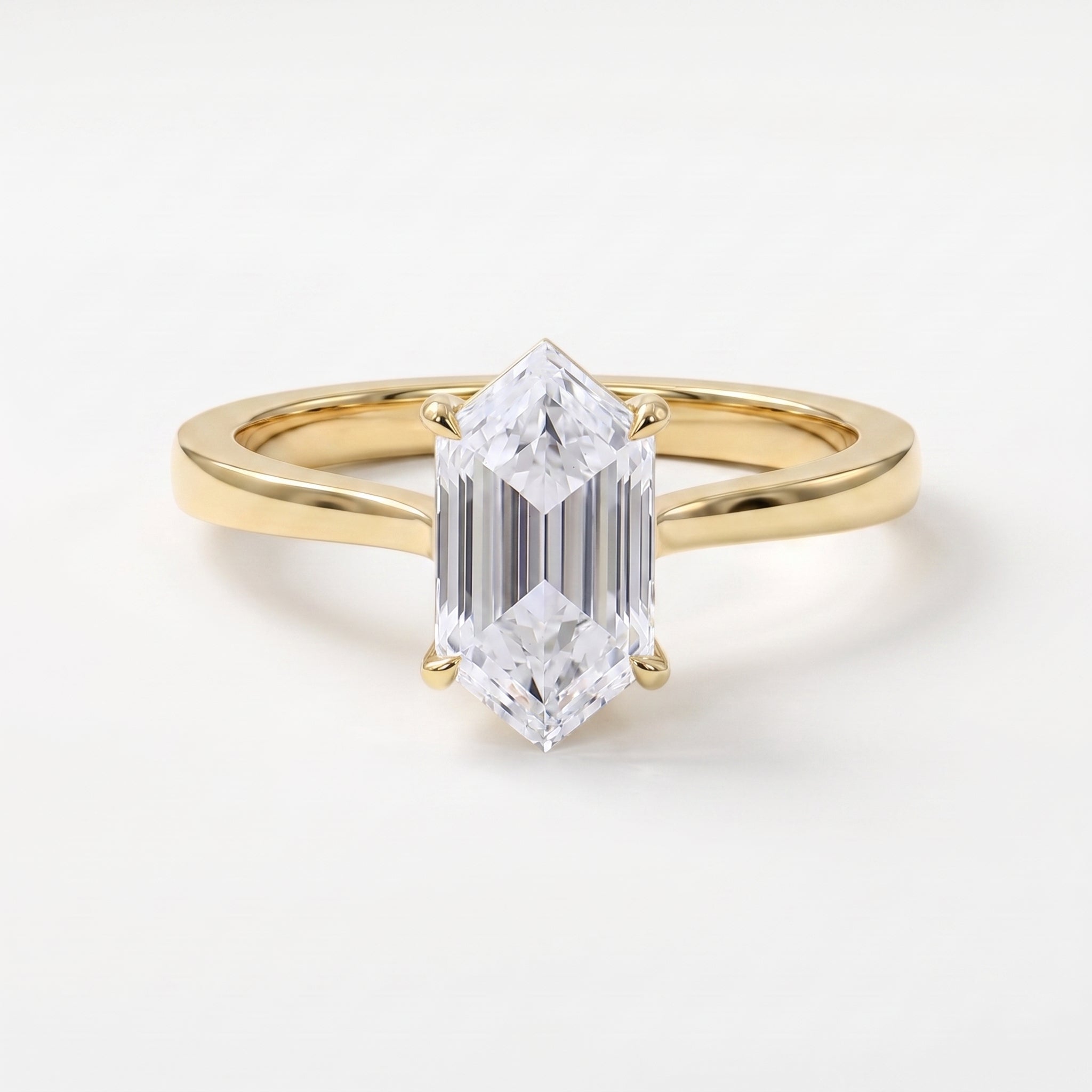 Modern elongated hexagon diamond solitaire engagement ring in polished yellow gold with a minimalist four-prong setting.