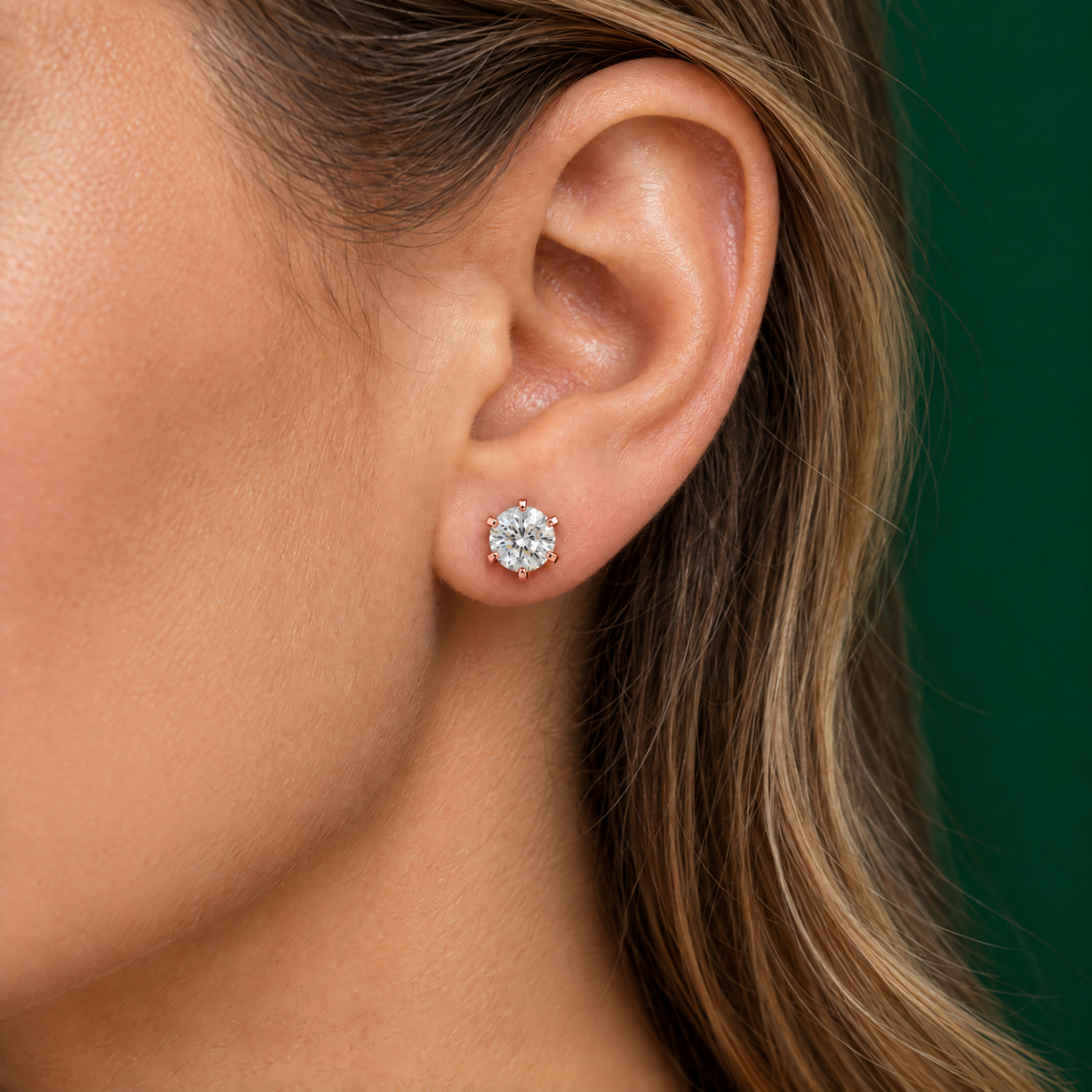 Diamond stud earring in 18K rose gold worn on the ear
