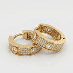 Luxury diamond huggie hoop earrings styled in elegant flat lay composition with premium jewelry aesthetic