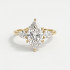 Marquise diamond three stone engagement ring in yellow gold with pear side diamonds on a clean white background