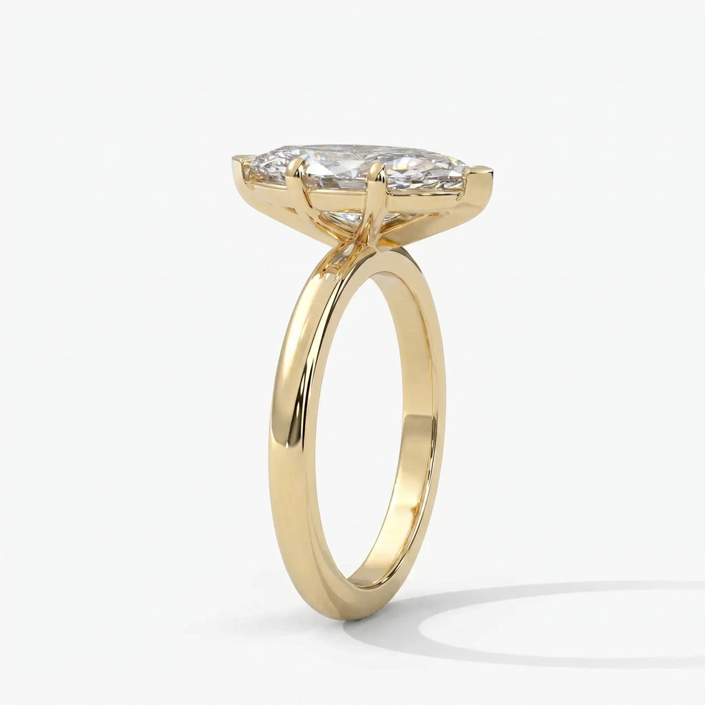 Luxury marquise solitaire engagement ring in yellow gold shown at a 45-degree angle highlighting sparkle.