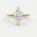 Marquise cut solitaire engagement ring in polished yellow gold with six-prong setting and brilliant center stone.