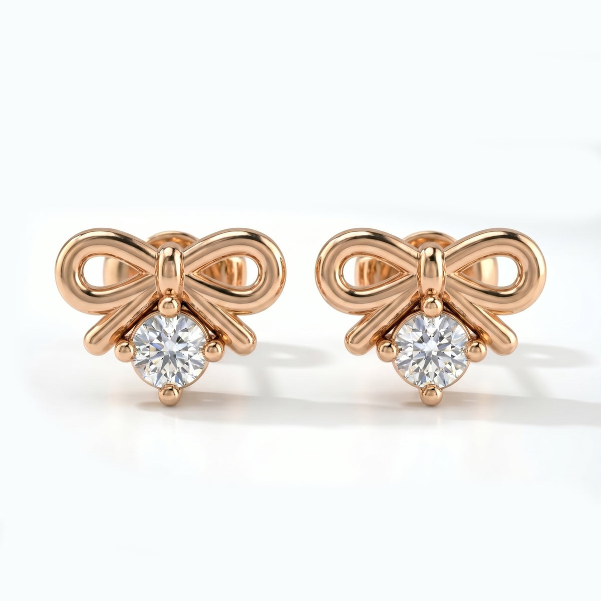 Rose gold bow stud earrings with round solitaire crystal on white background in minimalist luxury style