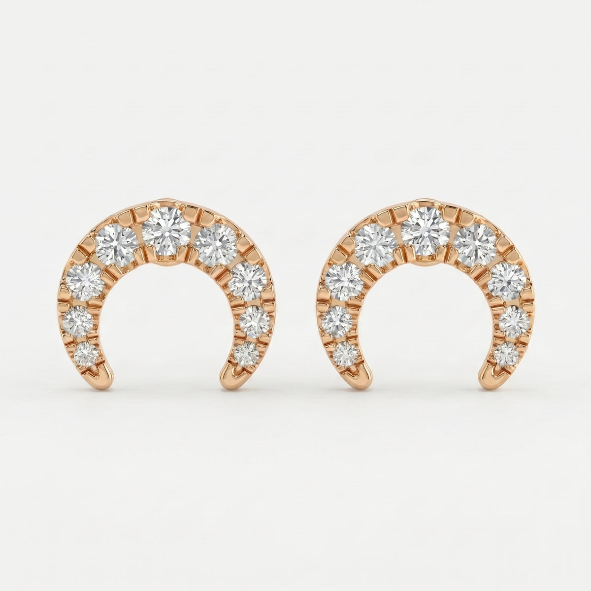 Rose gold horseshoe stud earrings with round diamonds on white background, minimalist luxury jewelry design